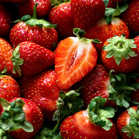 Close-up of fresh strawberries with a halved strawberry in the center.
