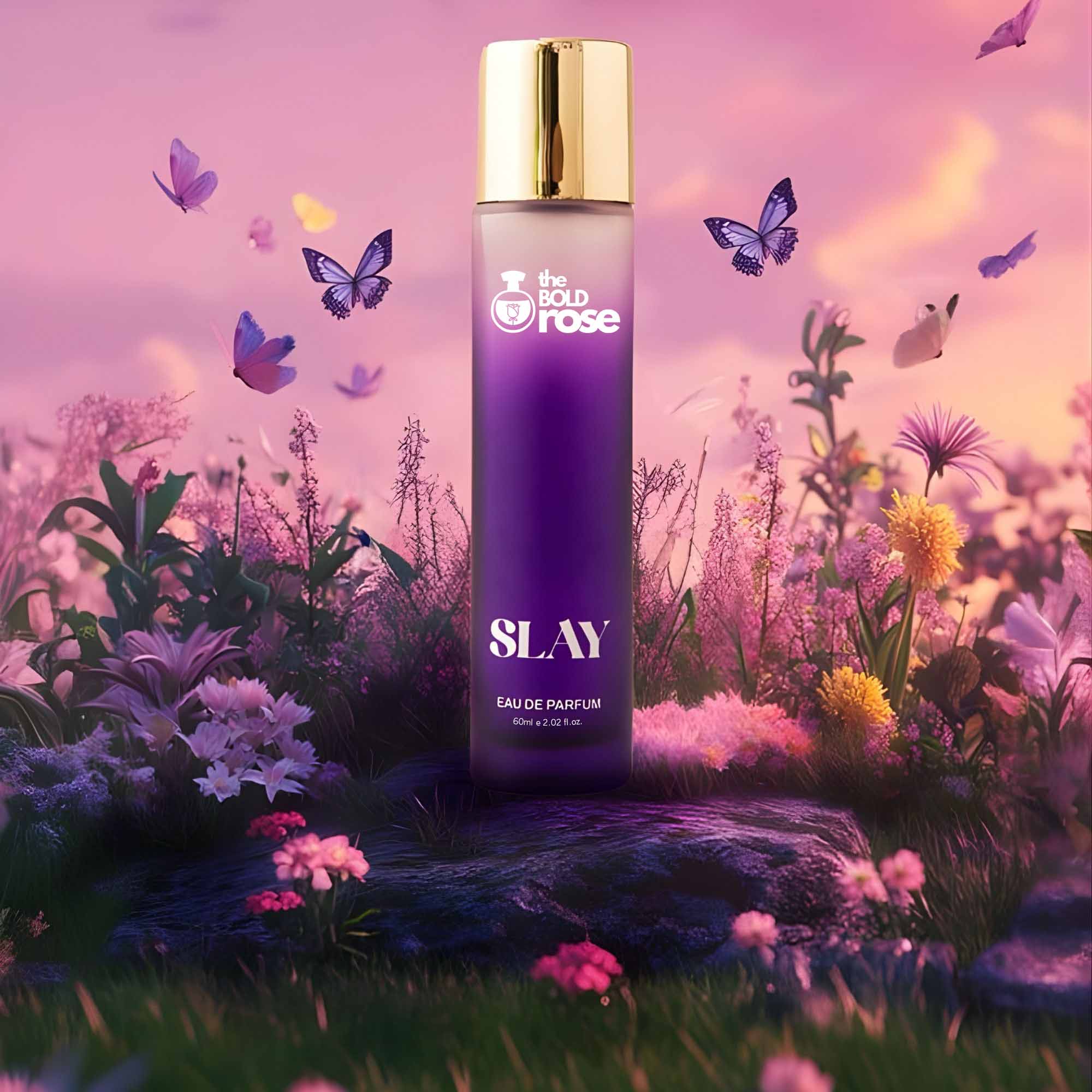 The Bold Rose Slay perfume placed in a dreamy floral landscape with butterflies, highlighting its soft elegant fragrance vibe.
