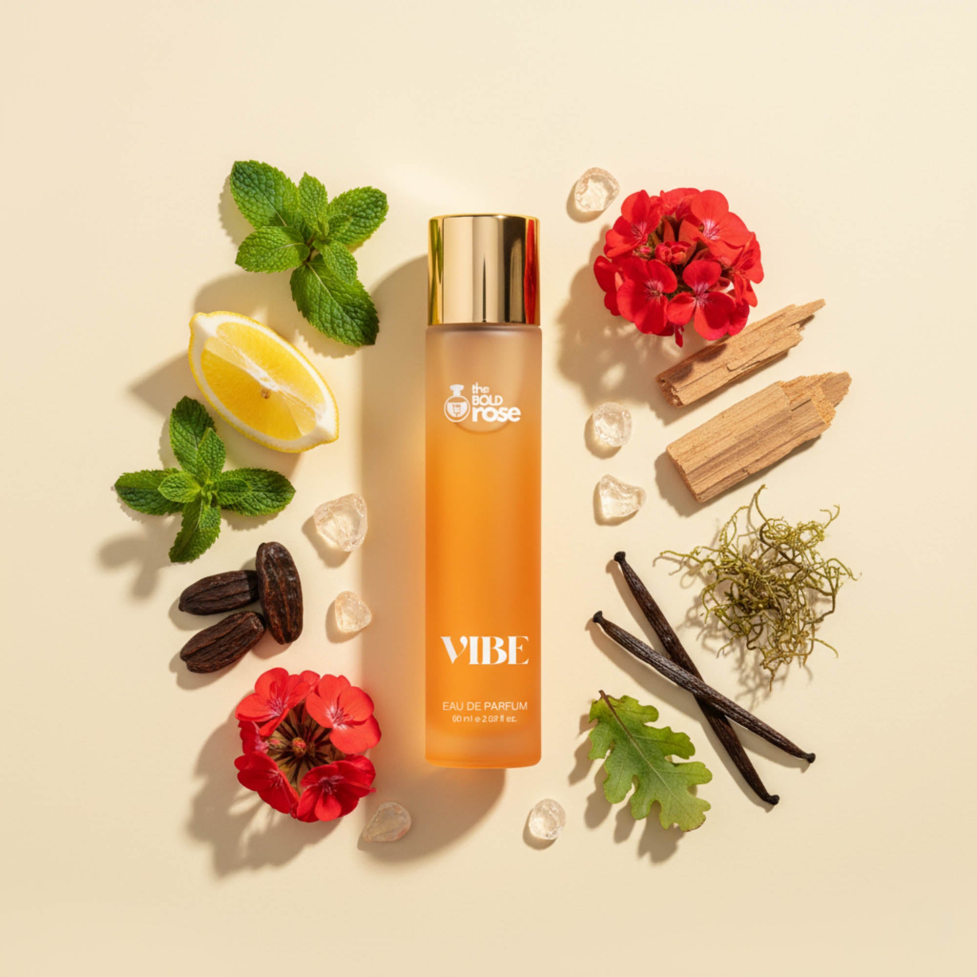 Vibe perfume flat-lay with mint, lemon, red flowers, vanilla pods, wood and resin crystals around the bottle on a clean beige background.